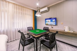 A room with a pool table, four chairs, a television, and a window with curtains. - Jingzhou Orange Flower Boutique Hotel (Shashi Tiandi Branch) (Jingzhou)