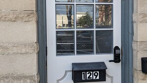 A white door with a mailbox labeled "129" and a keypad lock. - Studio with Queen Bed (Robinson)