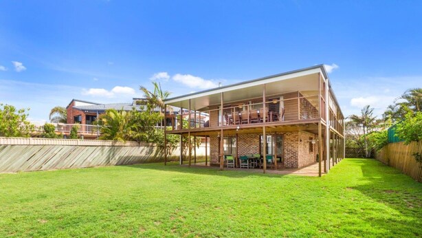 A two-story house with a large open patio area and a fenced backyard. - Deckhouse Surfside - Spacious Family Home with Beach Access (Pottsville)