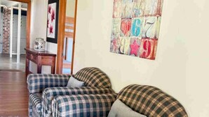A living room with plaid sofas and a colorful abstract wall art. - Deckhouse Surfside - Spacious Family Home with Beach Access (Pottsville)