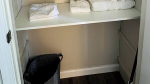Un placard avec trois étagères, chacune contenant des serviettes pliées.