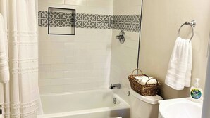 Une salle de bain avec douche, toilettes et lavabo.