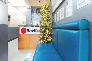 Un comptoir d’accueil Red Door, décoré d’un sapin de Noël et agrémenté d’un banc bleu.