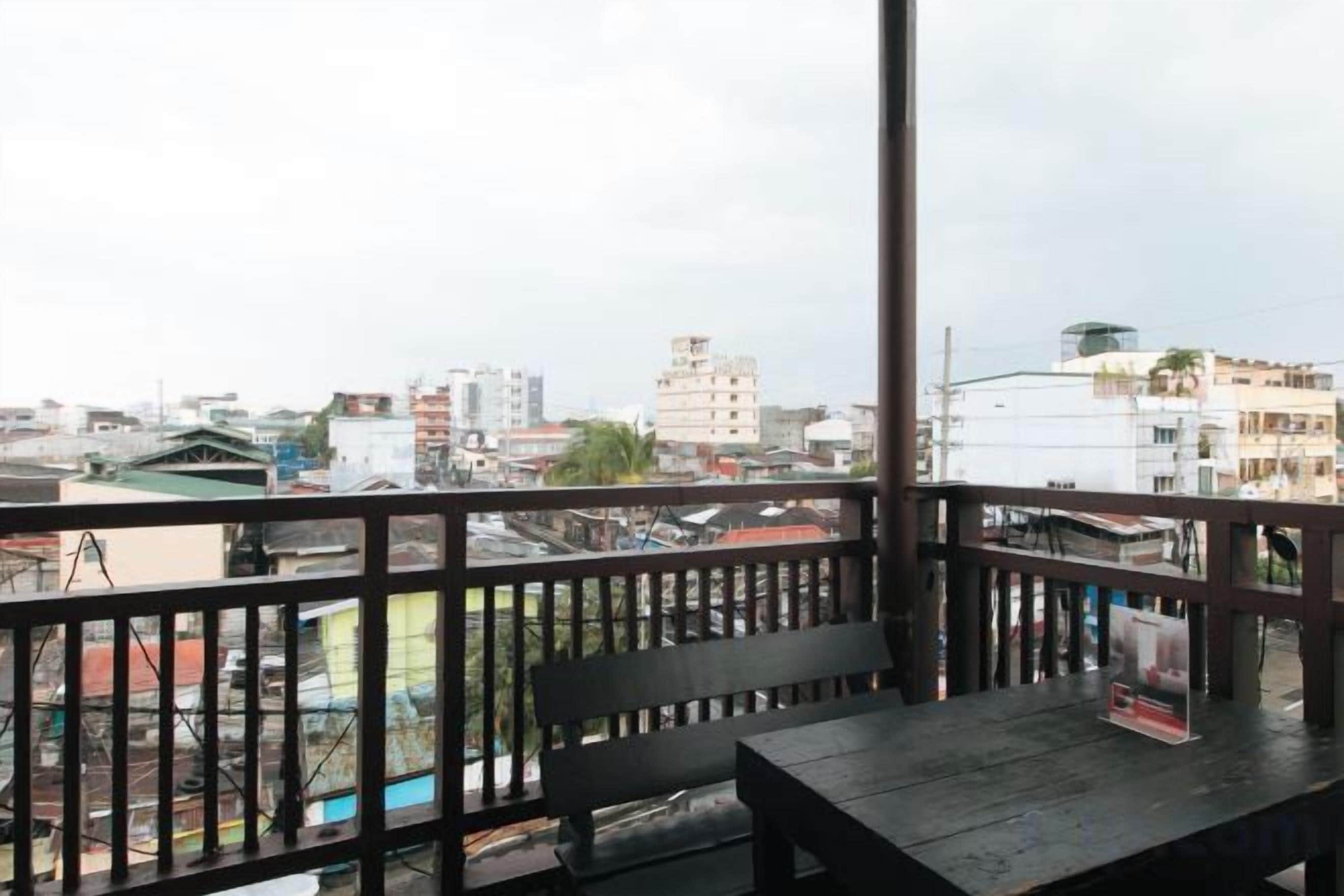 A balcony with a wooden railing, a bench, and a table.
