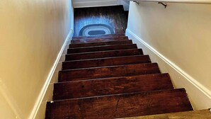 A wooden staircase with a handrail, leading to a landing with a window. - 2 Bedroom Near BP Refinery (Hammond)