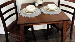 A dining table with two chairs, a decorative mirror, and a small potted plant. - 2 Bedroom Near BP Refinery (Hammond)