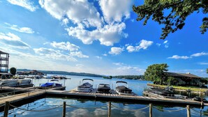 A wooden dock with boats and a building in the background. - Farr Shores Sunset Serenity (Hot Springs)