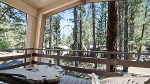 A wooden deck with a bench and a chair, overlooking a forested area. - Sherwood Cabin-2bed+Loft (Big Bear City)