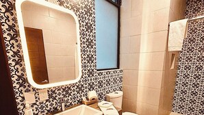 A bathroom with a sink, toilet, and shower area.