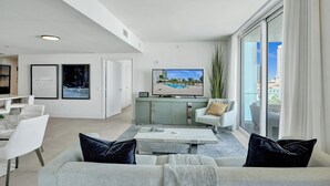 A modern living room with a sofa, coffee table, and a TV on a stand.