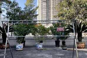 A rooftop garden with potted plants and a metal structure. - Junyu Boutique Hotel (Wanyuan Railway Station) (Wanyuan)