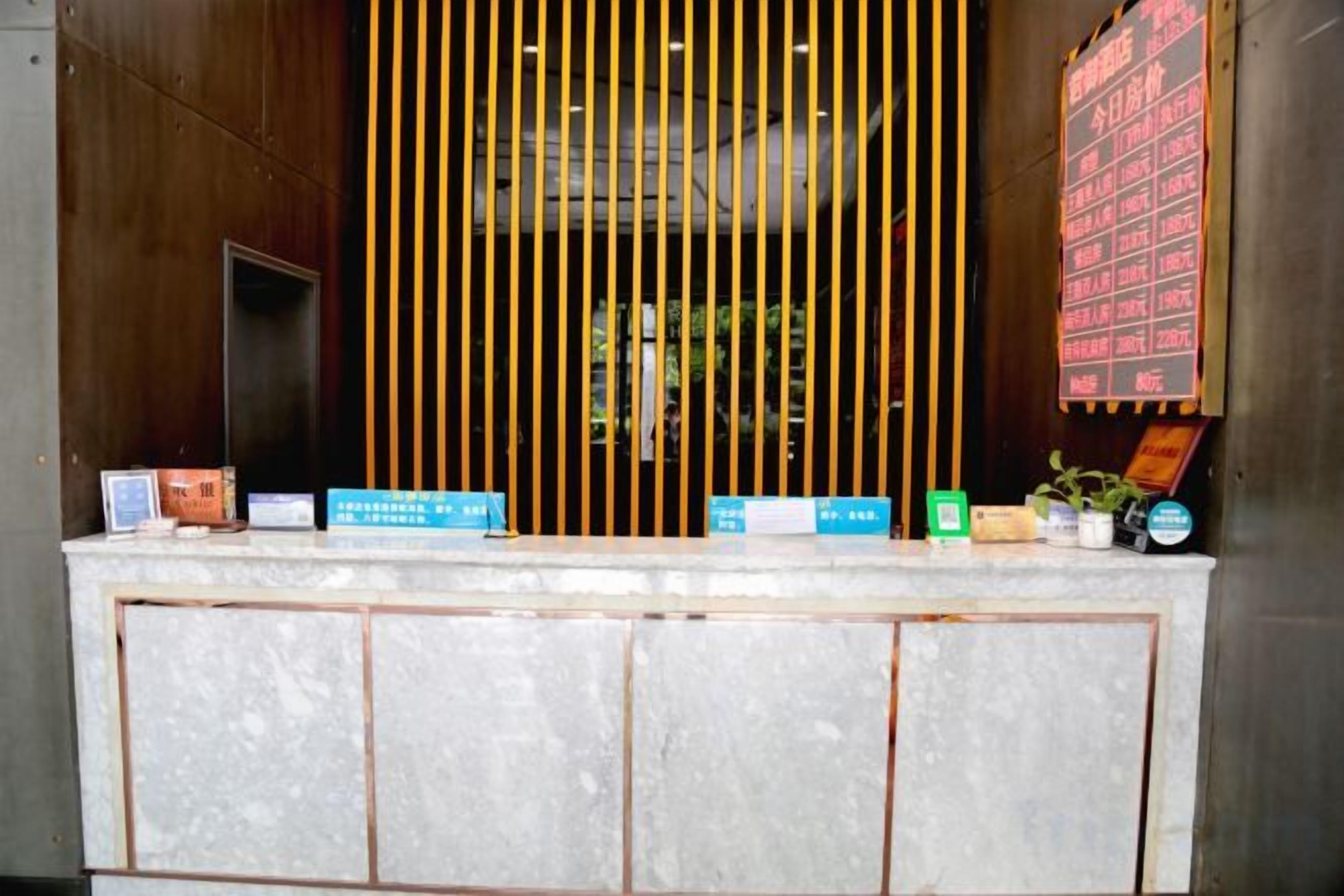 A reception desk with vertical blinds, a bulletin board, and a few informational signs.
