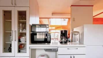 A compact kitchen with a microwave, coffee maker, and refrigerator.