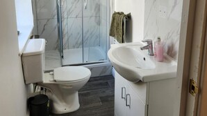 Un baño con inodoro, ducha y lavamanos.