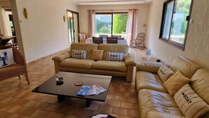 A spacious living room with a large sofa set, a coffee table, and a view through a sliding glass door. - Rental House La Tranche-sur-Mer à La Grière - 50m from the beach - 14 people (La Tranche-sur-Mer)