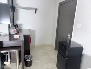 A compact kitchenette with a coffee maker, a trash bin, and a refrigerator. - Budget Inn (Nocona)