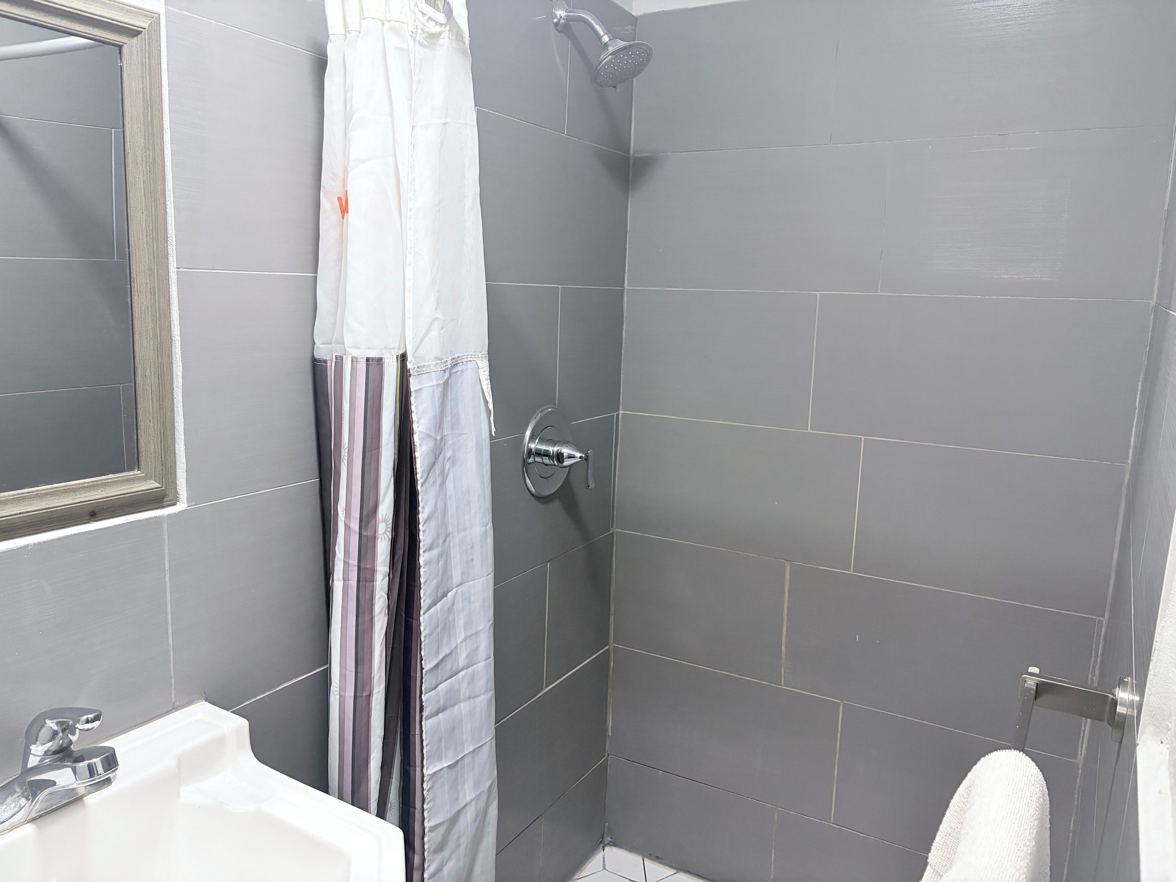 A bathroom with a shower, a sink, and a toilet.