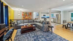 A modern living room with a sectional sofa, a coffee table, and a dining table with chairs. - Durham 4BR/3BA: Game Room, Pool, Art! Sleeps 10 (Durham)