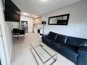 Relax in a spacious living area with a comfortable sofa and flat-screen TV.