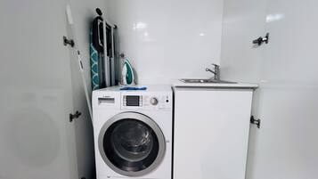 A compact laundry room with a Bosch washing machine and a small sink.