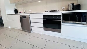 A modern kitchen with stainless steel appliances, a dishwasher, and a built-in oven.