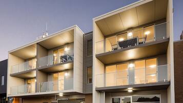A modern apartment building with multiple balconies, a reception area, and a garage.