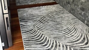 Una cucina moderna con ripiani in marmo, forno integrato e pavimento in legno.