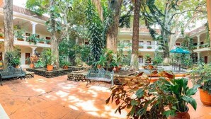 A spacious courtyard with multiple levels of balconies, potted plants, and outdoor seating areas.