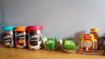Verschiedene Lebensmittel, darunter Senseo-Kaffeegläser und Gewürze, auf einer Holztischplatte.