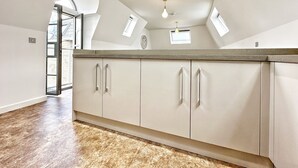 A spacious kitchen with a large island, recessed ceiling lights, and a view of the outside through a window. - Luxurious house in central Cambridge  (Cambridge)