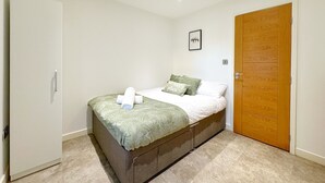 A bedroom with a bed, a wardrobe, a door, and a wall-mounted picture. - Luxurious house in central Cambridge  (Cambridge)