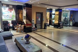 A hotel lobby with a reception desk, seating area, and a staircase. - Juli Boutique Hotel (Kunming Jinma Zhengchang Fruit Market Juhua Subway Station) (Kunming)