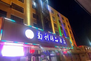 A building with illuminated signage, multiple floors, and a series of windows. - Juli Boutique Hotel (Kunming Jinma Zhengchang Fruit Market Juhua Subway Station) (Kunming)