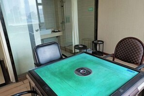 A room with a green carpeted table, a chair, a small stool, and a checkered chair. - Juli Boutique Hotel (Kunming Jinma Zhengchang Fruit Market Juhua Subway Station) (Kunming)