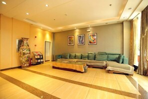 A spacious room with a large sofa, a decorative vase, and artwork on the wall. - Juli Boutique Hotel (Kunming Jinma Zhengchang Fruit Market Juhua Subway Station) (Kunming)