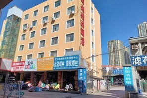 A multi-story building with several ground-floor shops. - Juli Boutique Hotel (Kunming Jinma Zhengchang Fruit Market Juhua Subway Station) (Kunming)