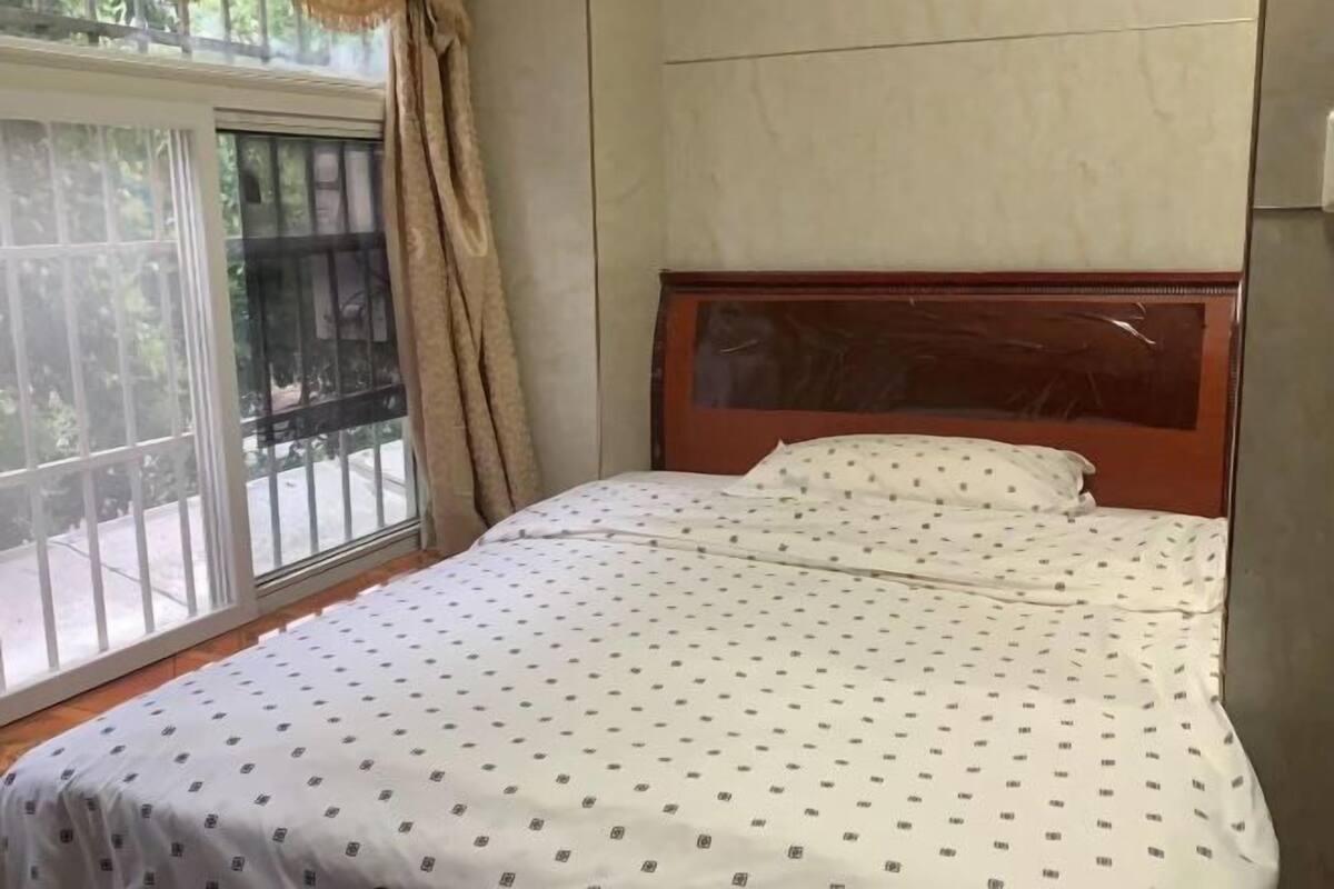 Un dormitorio con cama, ventana y puerta.