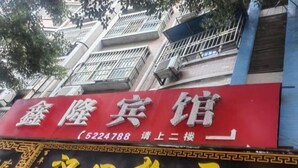A red sign with white and yellow text for a hotel, including a phone number and a directional arrow. - Danjiangkou Xinlong Hotel (Danjiangkou)