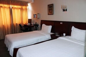 A hotel room with two beds, a desk, and a chair. - Danjiangkou Xinlong Hotel (Danjiangkou)