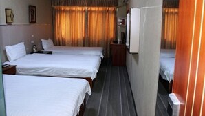 A hotel room with three single beds, a small table, a TV, and a wardrobe. - Danjiangkou Xinlong Hotel (Danjiangkou)