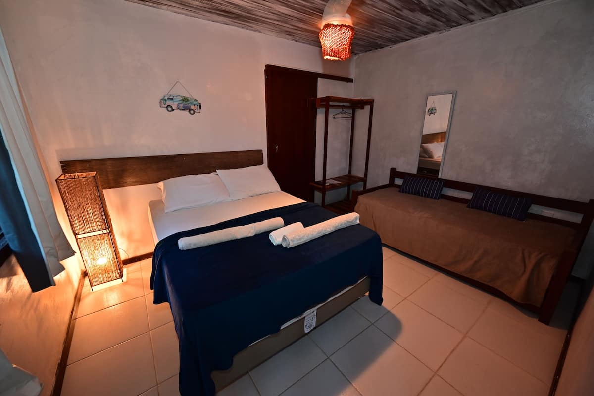 Ein Schlafzimmer mit Bett, Nachttisch und Hängesessel.