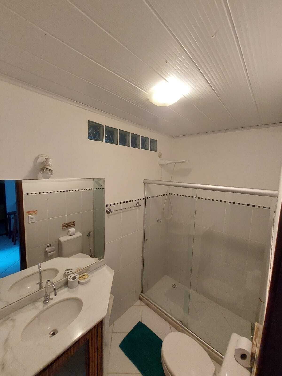 A bathroom with a sink, toilet, and glass shower enclosure.