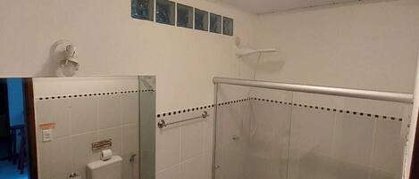 A bathroom with a sink, toilet, and glass shower enclosure.