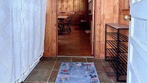 A wooden hallway with a dining area visible through an open door.