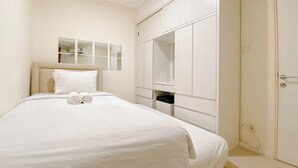 Une chambre à coucher avec un lit, une armoire et un miroir.