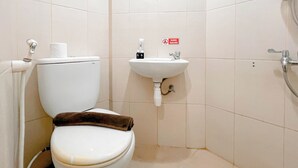 Een kleine badkamer met toilet, wastafel en douche.