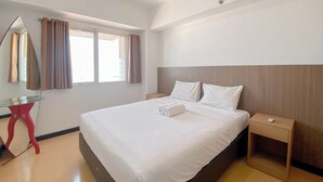 Une chambre d’hôtel avec un grand lit, une table de chevet, une commode, un miroir et une fenêtre avec des rideaux.