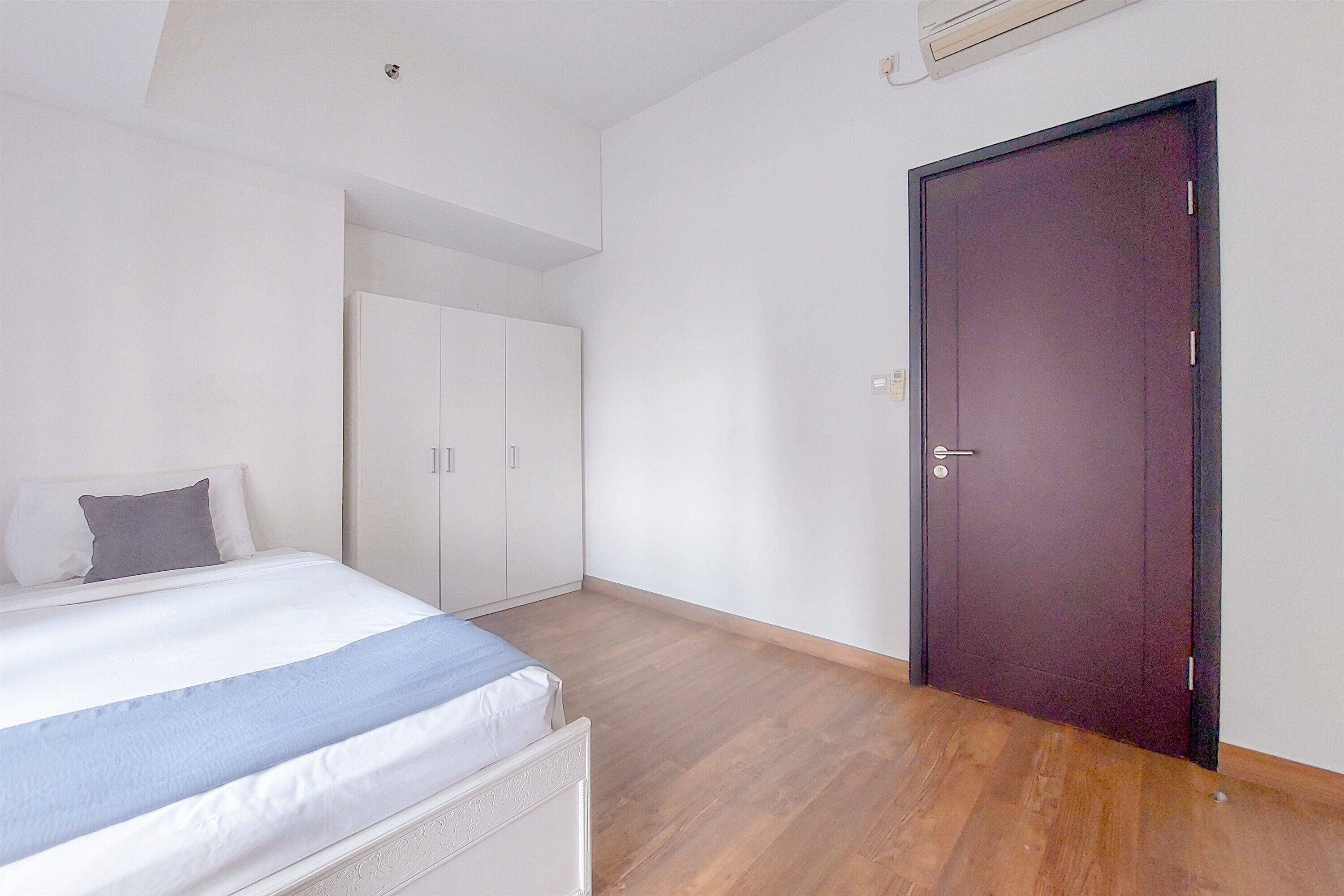 Un dormitorio con cama, armario y puerta.