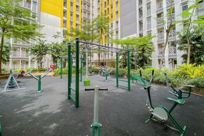 An outdoor gym area with exercise equipment, surrounded by greenery and residential buildings. - Cozy Living Studio With Direct Access To Pool, Gym And Playground At Springlake Summarecon Bekasi (Bekasi)