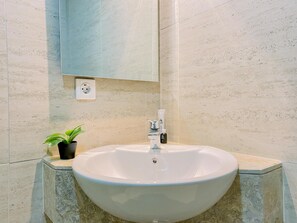Ein Badezimmer mit Waschbecken, einem Blumentopf und einem Spiegel.